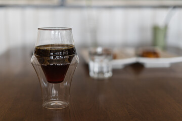 Freshly brewed hot coffee drip in a glass coffee cup