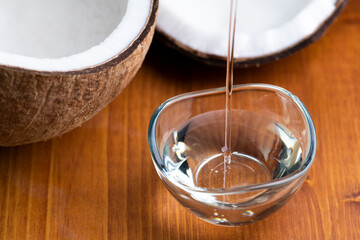 割られたココナッツから見える胚乳とココナッツオイル