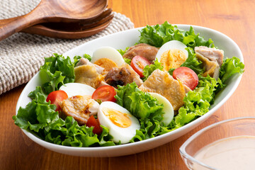 食卓のテーブルに香ばしい鶏もも肉のグリルチキンサラダ