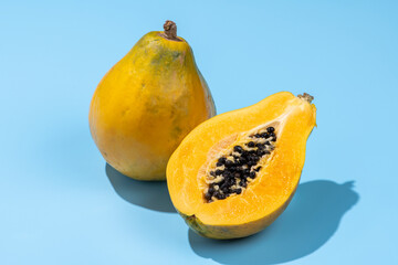 青色の背景にカットした黄色の完熟パパイア