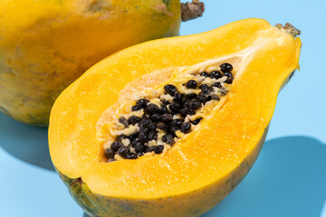 青色の背景にカットした黄色の完熟パパイア