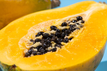 青色の背景にカットした黄色の完熟パパイア