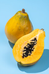 青色の背景にカットした黄色の完熟パパイア