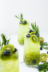 Refreshing drink with kiwi smoothie, summer sweet fruit juice with blueberries and rosemary