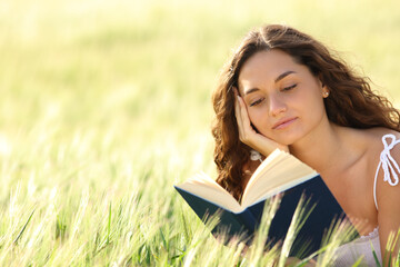 Woman reading a paper book in a wheat field