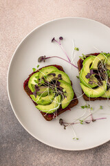 Sandwiches with boiled beetroot and avocado with microgreens, delicious healthy breakfast