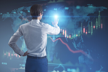 Stock market and trading concept with man back view touching digital wall screen with world map and financial chart candlestick and diagram