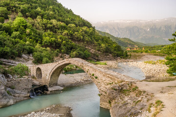 Fototapeta na wymiar Old arch shape stone bridge and Benja Thermal Baths in Permet, Albania