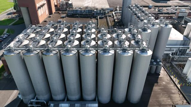 American brewery. Holding tanks for beer at processing brewery where distillation and fermentation occur. Aerial.