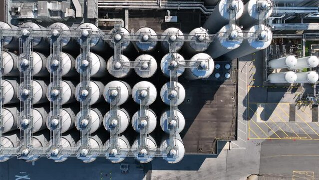 Top down aerial of beer brewery fermentation tanks. Round stainless steel cylinder holding reservoirs.