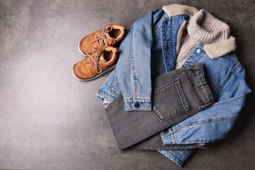 Warm child clothes and shoes on grey background, flat lay. Space for text