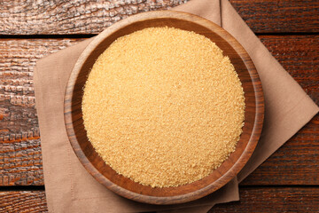 Brown sugar in bowl on wooden table, top view