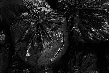 Black trash bags full of garbage as background, top view