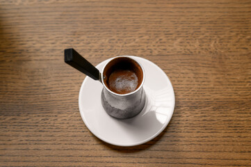 Jezve with fresh coffee on wooden table, above view
