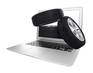Online auto store, delivery service. Modern laptop and car tires on white background