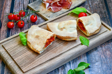 Home made italian calzone vegetarian  pizza with  tomatoes, mozzarella and parmesan cheese and fresh basil 
