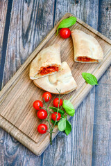 Home made italian calzone vegetarian  pizza with  tomatoes, mozzarella and parmesan cheese and fresh basil 