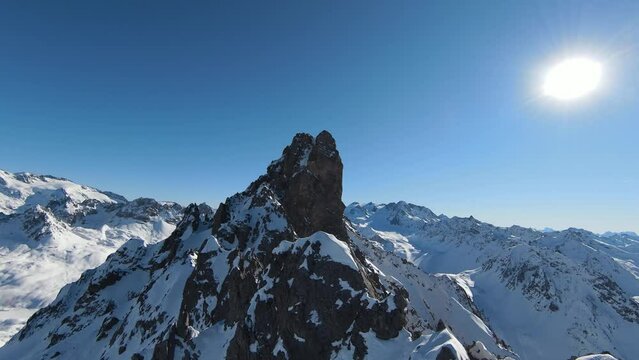 Aerial view sport FPV drone raising up top of mount. Beautiful peaks of the alps covered with snow cover