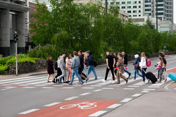 People crossing street in city. Zebra markings
