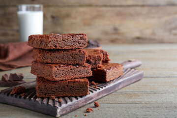Delicious chocolate brownies on wooden table. Space for text