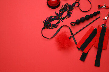 Sex toys and accessories on red background, flat lay. Space for text