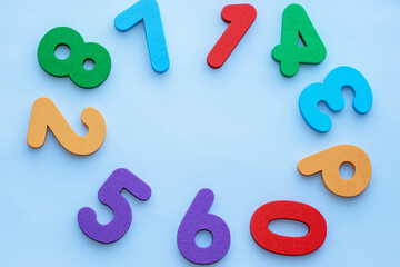 wooden eco numbers toys placed like a clock shape,circle,free space in the middle.education,learning concept.back to school.light blue background