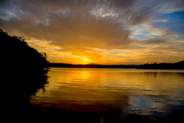 Beautiful sunset on tranquility lake river sea. Water reflections stunning nature background
