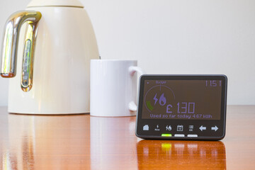 Smart meter placed on a table with a kettle and a mug