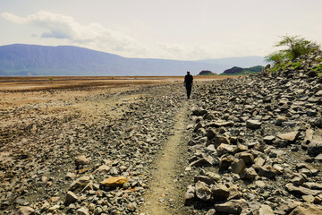 A tourist walking on the beach of Lake Natron on a sunny day in rural Tanzania