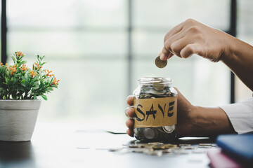 Fototapeta na wymiar woman hand putting money into jar
