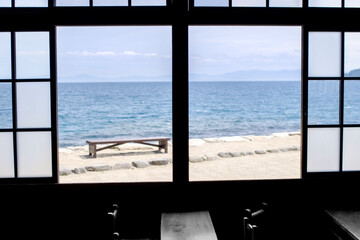 窓越しの海とベンチ
