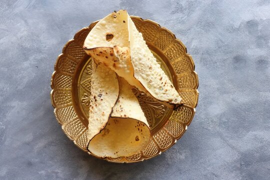 Urad dal roasted papad. It is an Indian crispy popular snack that is a side dish for lunch and dinner. Roasted roll papad with copy space. Perfect to have it with Dal rice.
