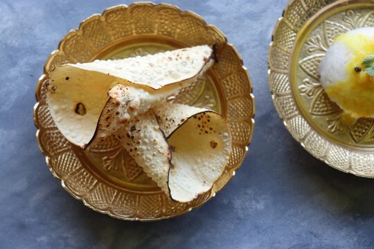 Urad dal roasted papad. It is an Indian crispy popular snack that is a side dish for lunch and dinner. Roasted roll papad with copy space. Perfect to have it with Dal rice.