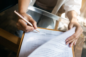 Focus at pen on female hand sign business contract to make sale purchase deal, write signature on...