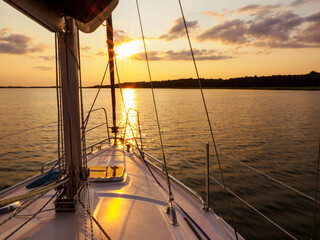 sailing yacht bow in sunset light, sailing on a lake