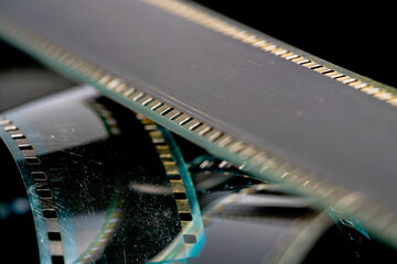 Black swirling strips of old analog film with scratches and scuffs. Photo or video film for films...