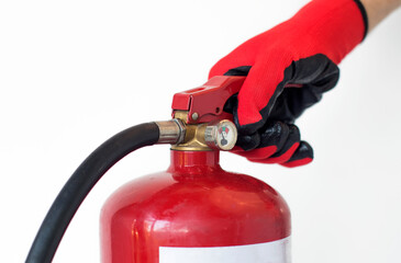 Naklejka premium Concept for handling fire extinguishers, a gloved hand presses the lever of a fire extinguisher