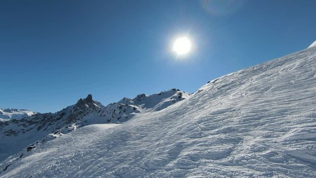 Aerial view sport FPV drone raising up top of mount. Beautiful peaks of the alps covered with snow cover