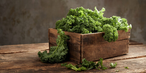 Fresh green kale cabbage in wooden container on table