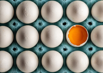 Organic fresh chicken eggs arranged in egg tray. half broken egg with yolk visible