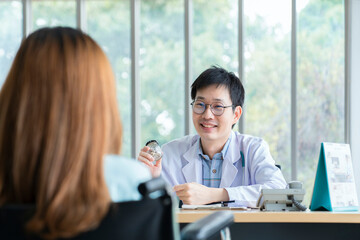 Fototapeta premium Smiling Asian male pediatrician give advice to patients , Young asia male doctor consult female patient and checkup in hospital , healtcare and assistance concept
