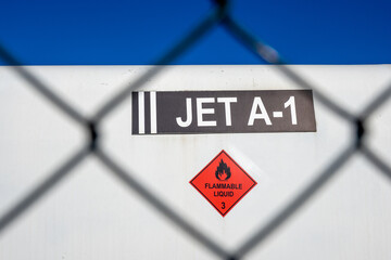 A jet A-1 fuel tank through a security fence cell at an airport fuel terminal