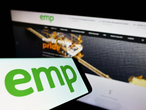 Stuttgart, Germany - 05-22-2022: Cellphone with logo of Indonesian company PT Energi Mega Persada Tbk (EMP) on screen in front of website. Focus on center-left of phone display.