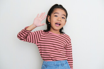 Asian little girl waving her hand to greet someone