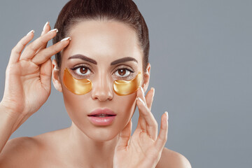 Beauty woman face with under eye collagen gold pads.  Anti-aging moisturizing eye mask, golden...