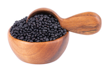 Black lentils in wooden bowl and spoon, isolated on white background. Dry beluga lentil grains pile.