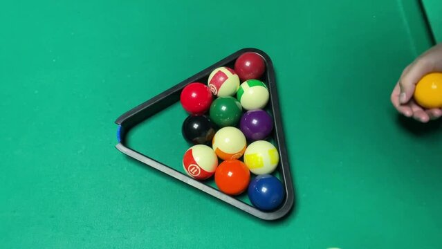 pool game, the player on the billiard table lays out the balls in the shape of a triangle to break