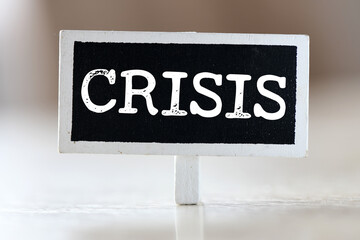 The word CRISIS on a small chalkboard.