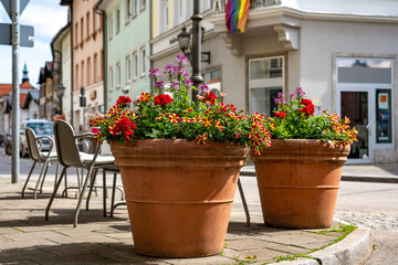 Fototapeta na wymiar Bunte Blumentöpfe in einem Straßencafé in der Altstadt