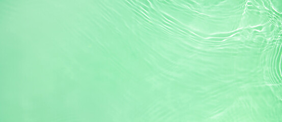 Abstract summer banner background Transparent green clear water surface texture with ripples and...